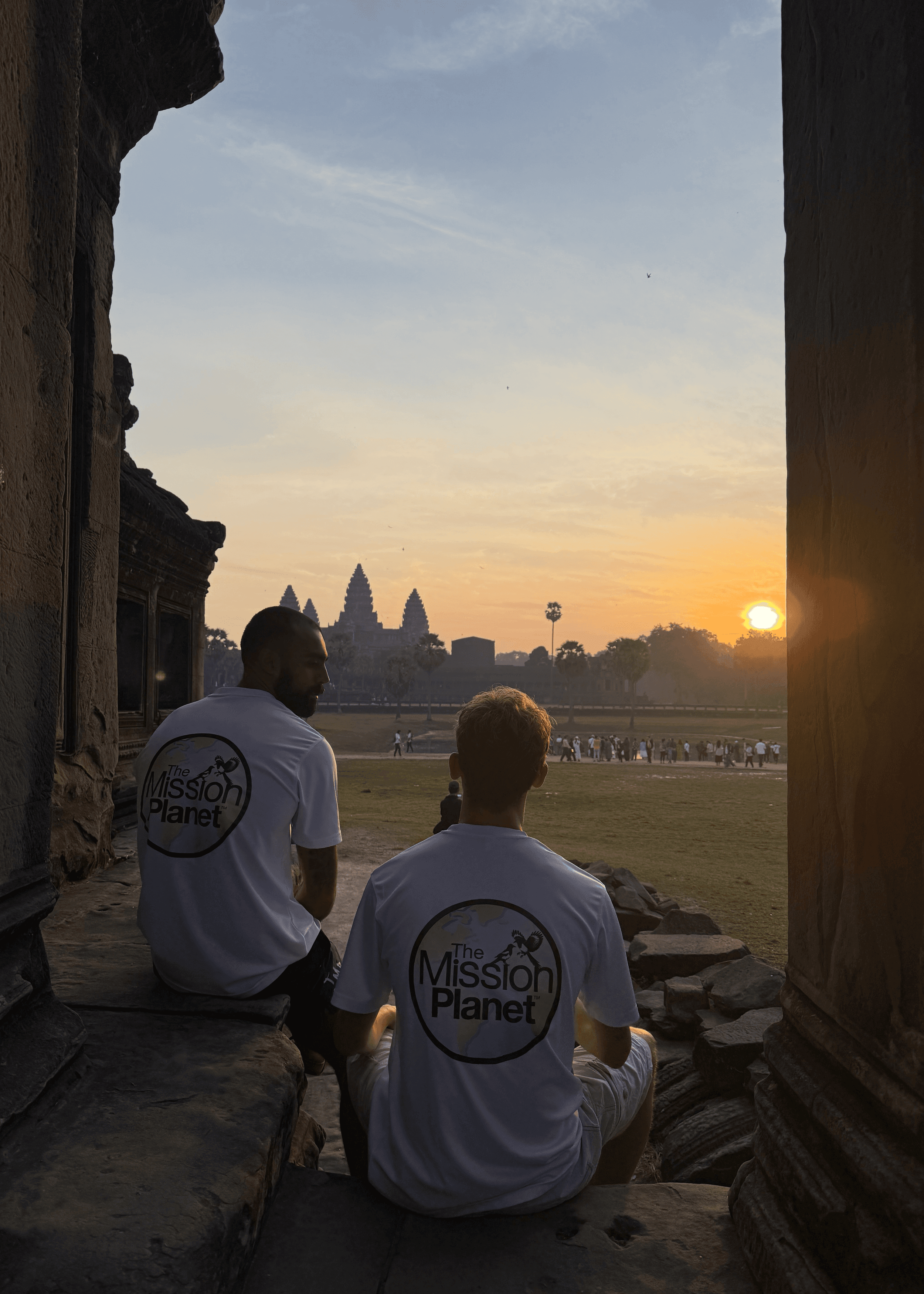 Rohan and Tom wearing Mission Planet t-shirts watching the sunset at Angkor Wat during a Mission Planet journey