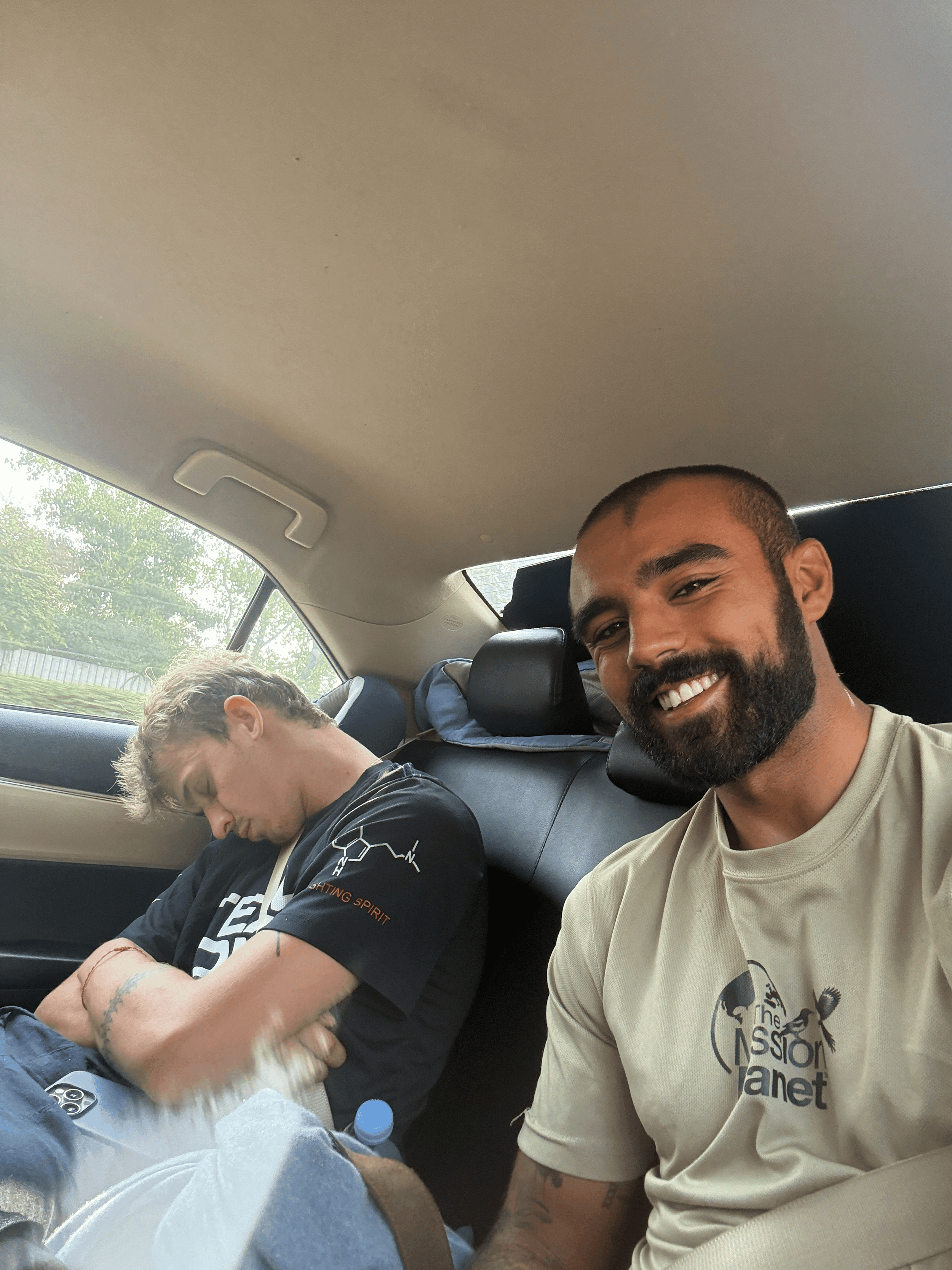 Rohan and Tom resting while travelling by car during a Mission Planet journey between mission locations