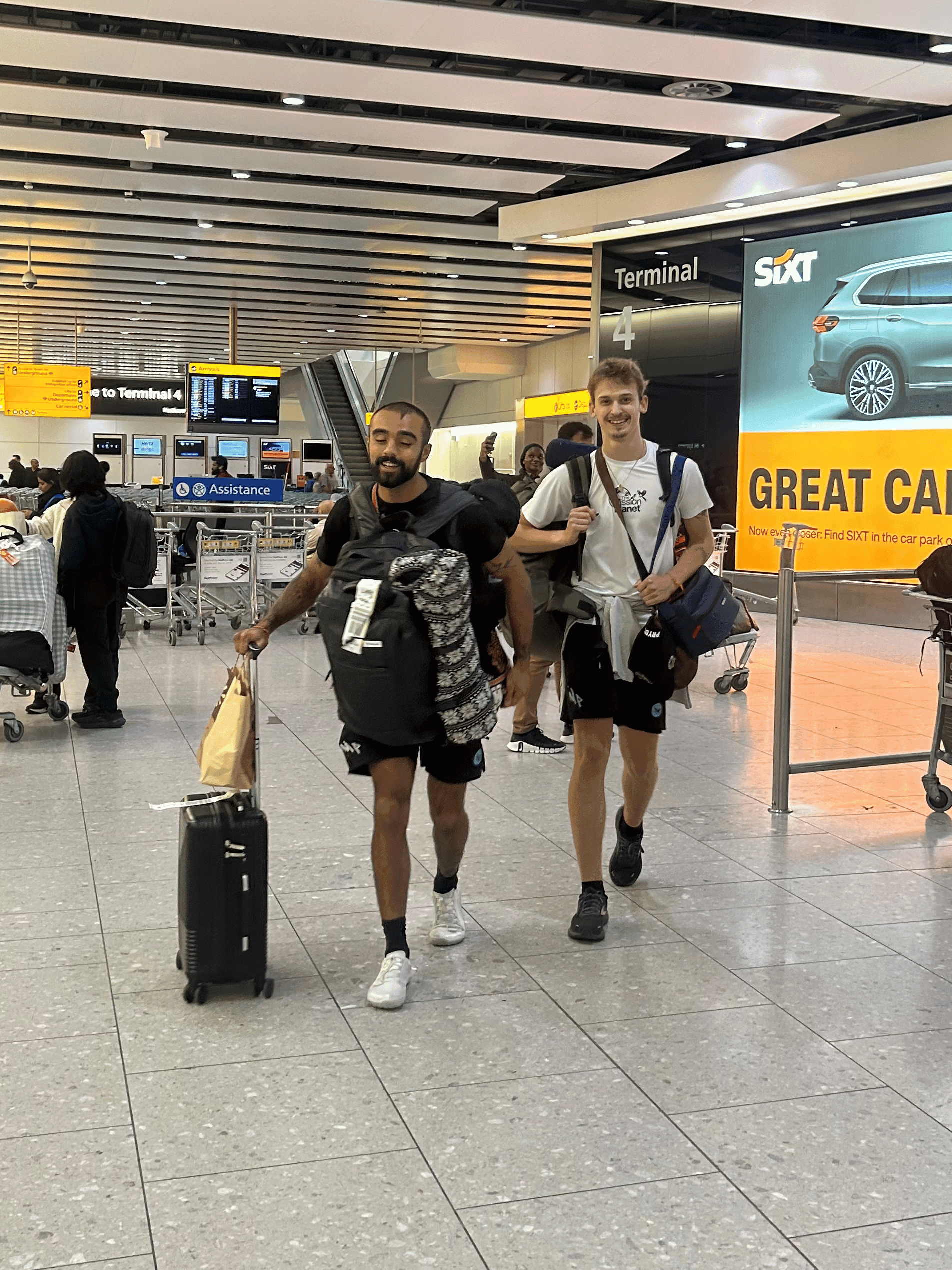 Rohan and Tom travelling through an airport at the start of a Mission Planet journey to support animal welfare missions
