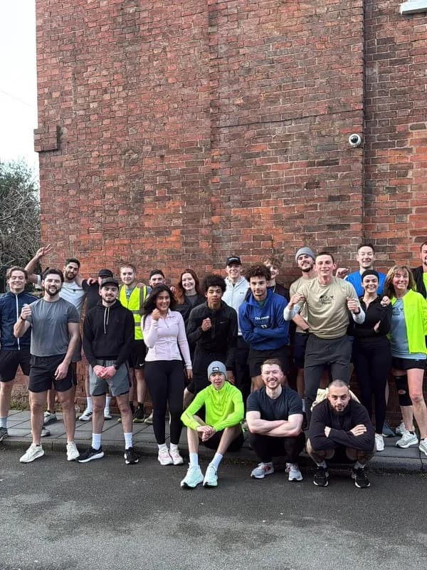 A large group gathered outside a brick building after a run