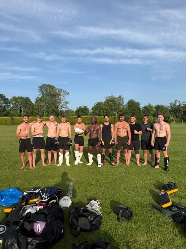 A group lined up on grass at the end of a session