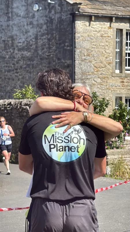 Two people hugging, one wearing a Mission Planet top