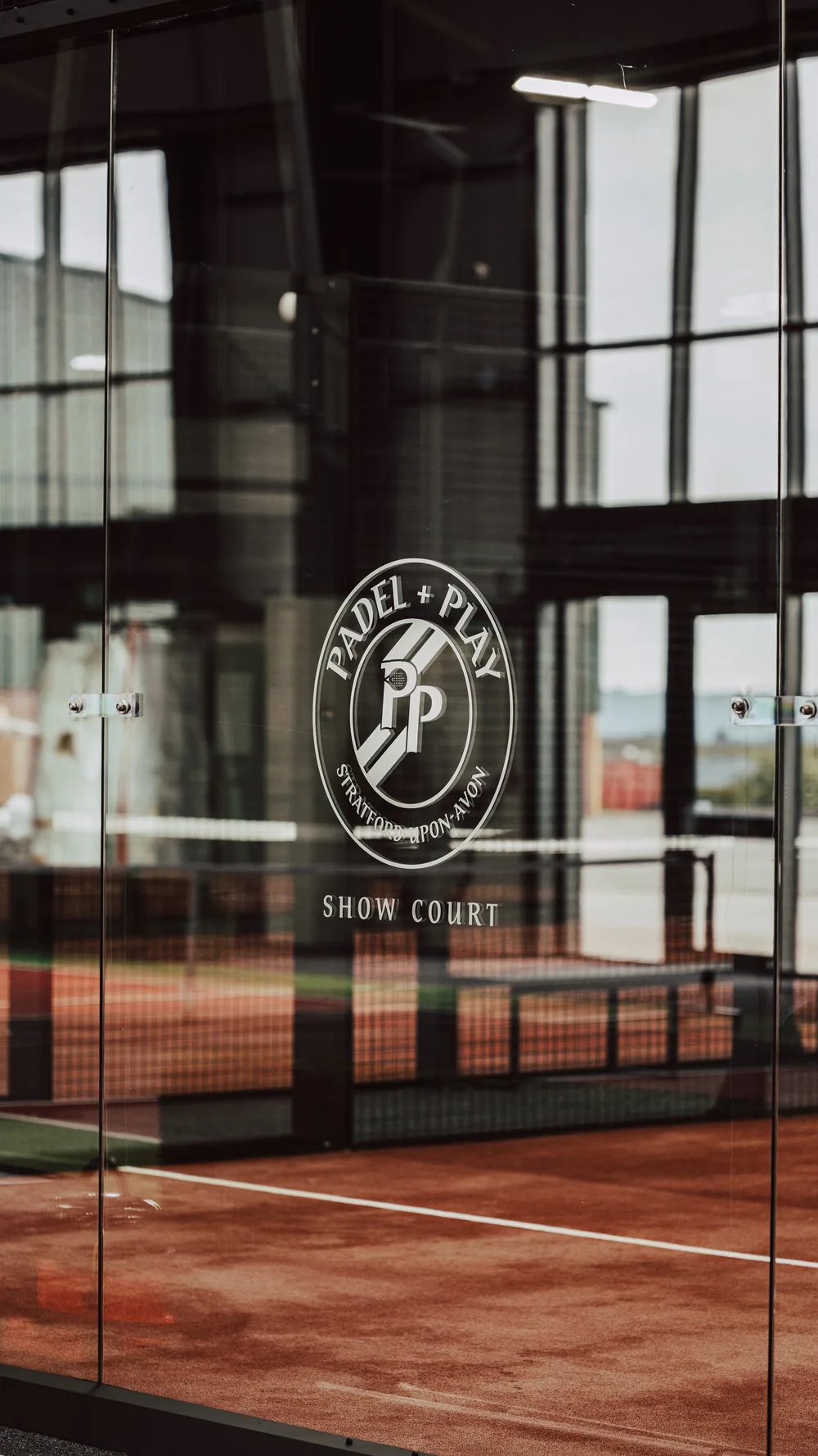 The Padel & Play show court entrance, with their logo etched on the glass