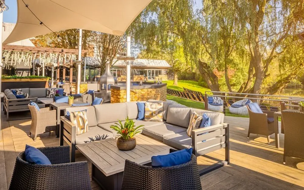 The hotel's riverside terrace, looking out over the lawn towards the water